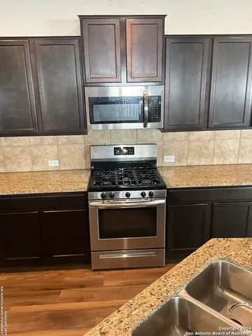 a kitchen with granite countertop stainless steel appliances and wooden cabinets