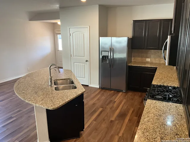 a kitchen with granite countertop a refrigerator and a sink