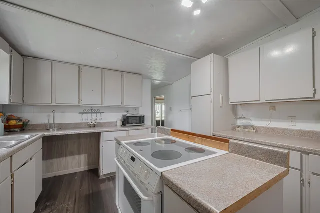 a kitchen with a sink a stove and cabinets