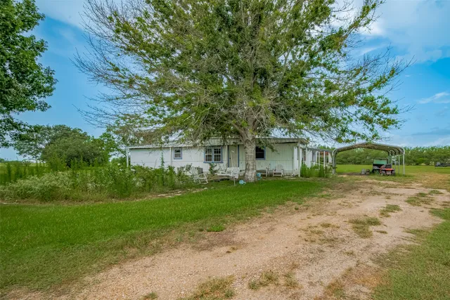 a front view of a house with a yard and trees