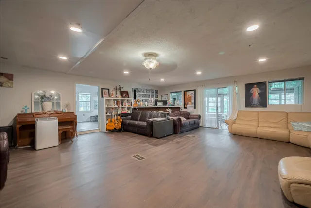 a living room with furniture and a wooden floor