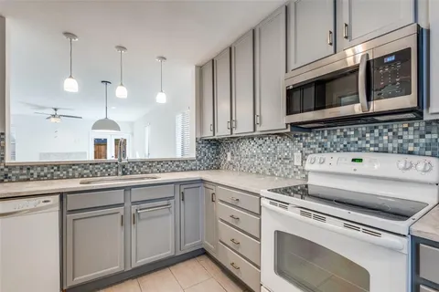 a kitchen with white cabinets and white appliances