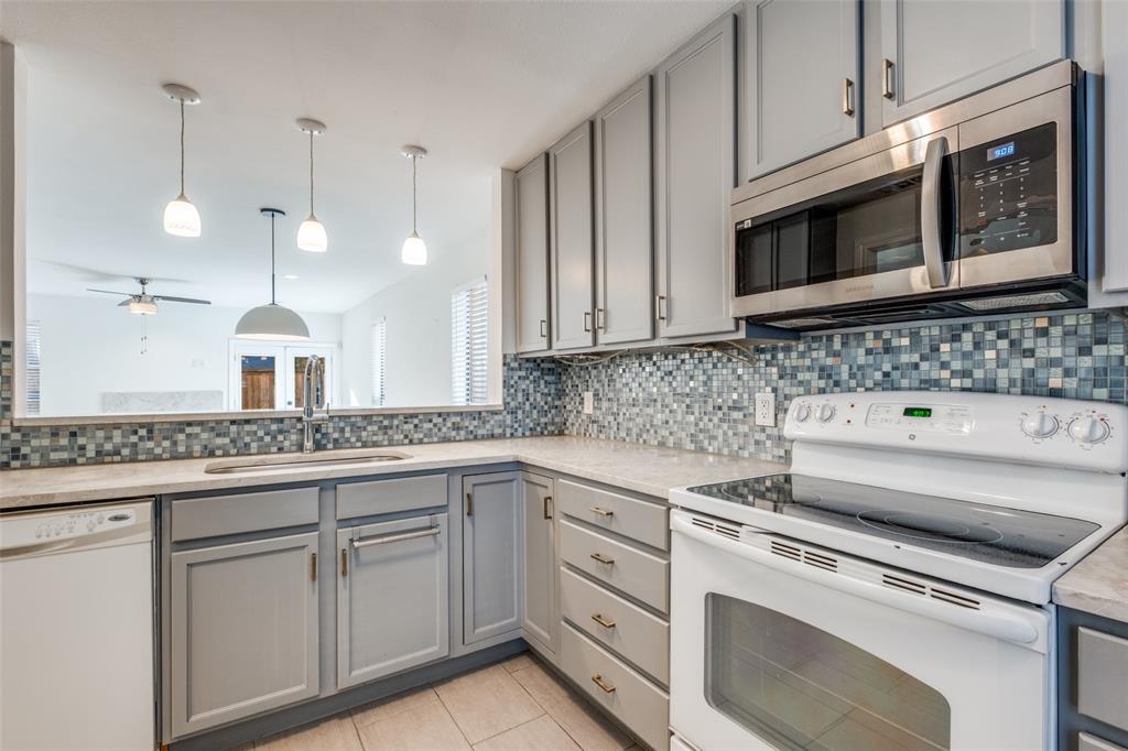 a kitchen with white cabinets and white appliances