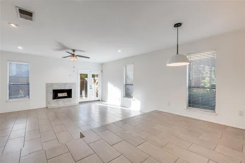 a view of an empty room with a fireplace and a window