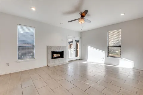 a view of an empty room with a fireplace and a window