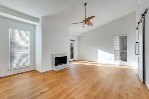 a view of empty room with wooden floor and fireplace