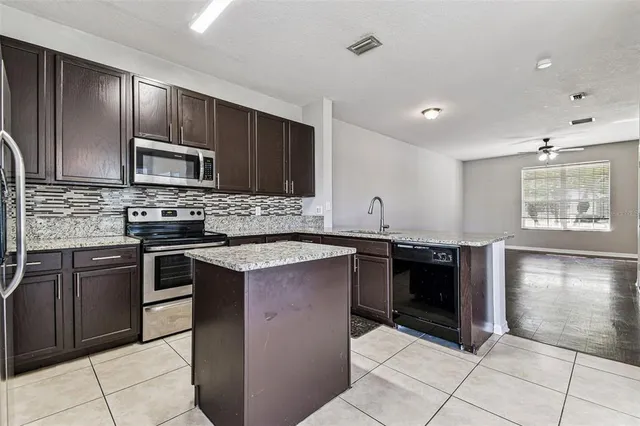 a kitchen with stainless steel appliances granite countertop a stove sink and microwave
