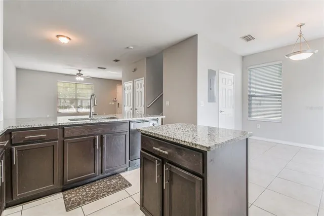 a kitchen with granite countertop cabinets stainless steel appliances a sink and a window