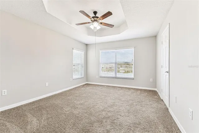 an empty room with a window and a fan