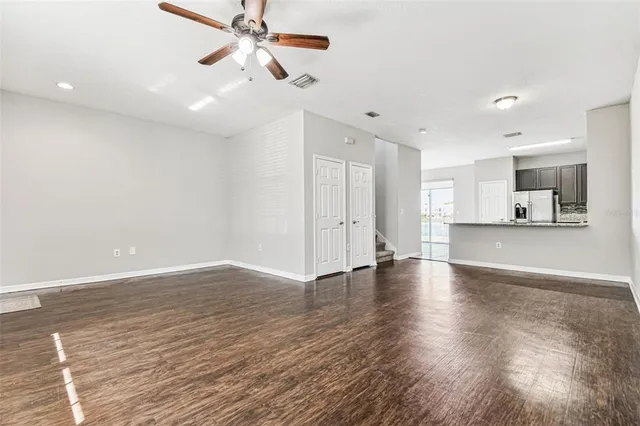 a view of an empty room with window and wooden floor