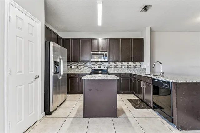 a kitchen with a refrigerator sink and cabinets