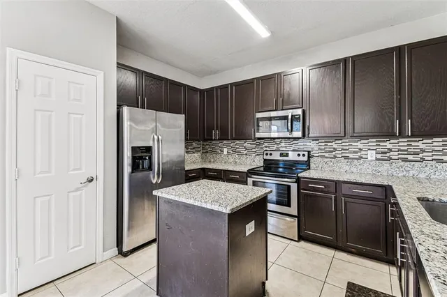 a kitchen with granite countertop wooden cabinets and stainless steel appliances
