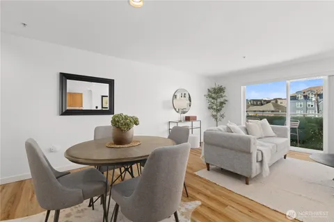 a living room with furniture a table and a large window