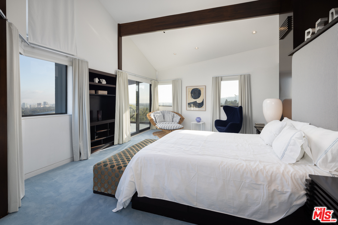 1375 Summitridge Place Beverly Hills, CA 90210 - Photo 11 of 21 a bedroom with a bed and a large mirror