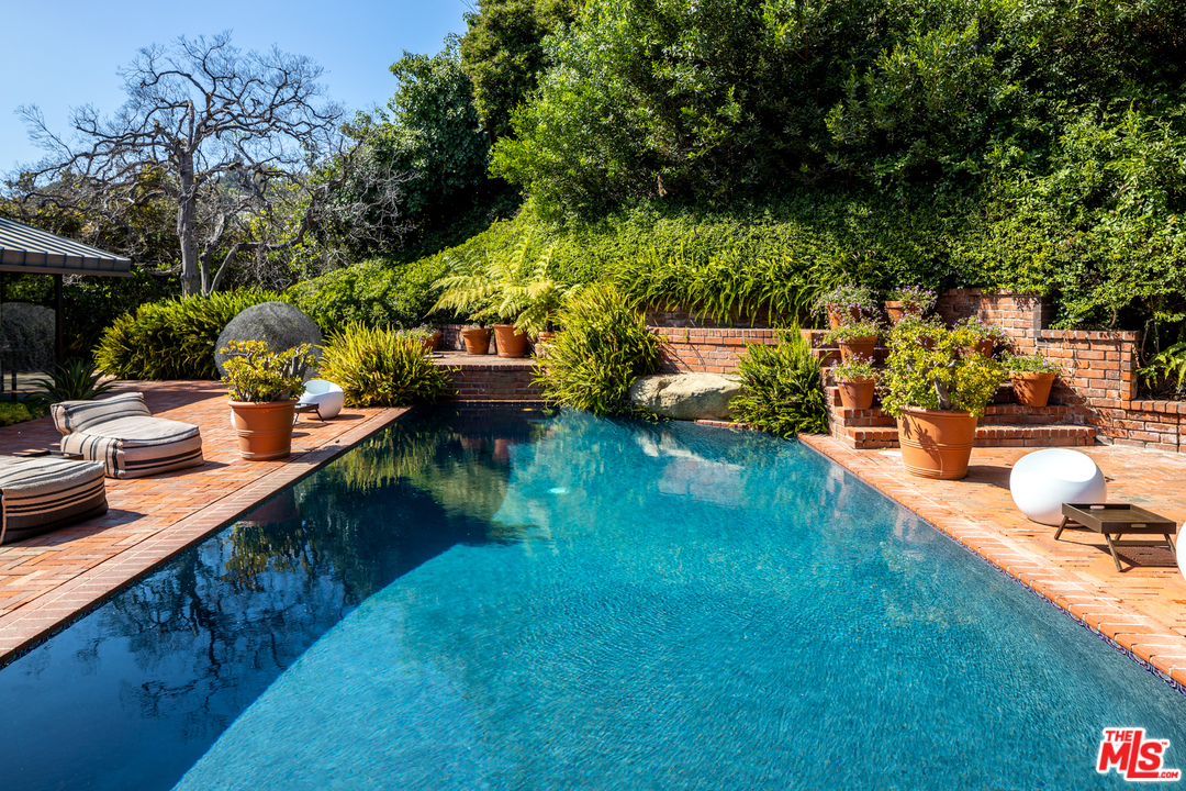 1375 Summitridge Place Beverly Hills, CA 90210 - Photo 17 of 21 a view of swimming pool with lawn chairs and plants