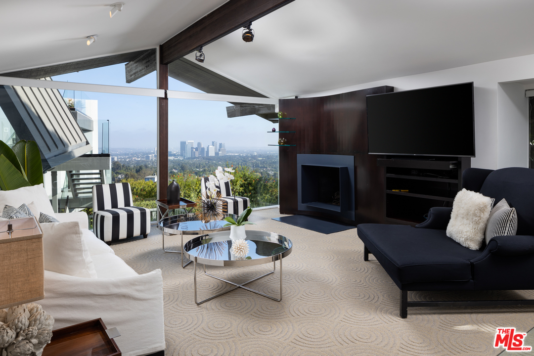 1375 Summitridge Place Beverly Hills, CA 90210 - Photo 8 of 21 a living room with furniture fireplace and a flat screen tv