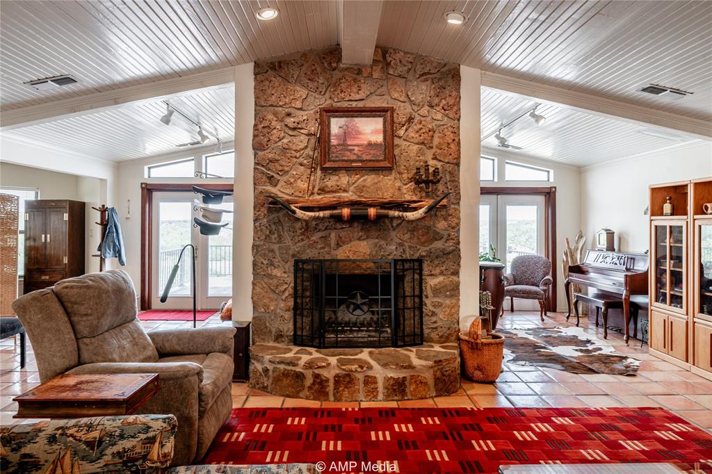 1982 Mountain Pass Merkel, TX 79536 - Photo 1 of 40 Living room featuring wood ceiling, tile patterned flooring, beamed ceiling, a fireplace, and high vaulted ceiling