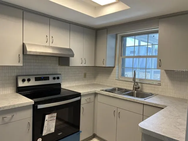 a kitchen with stainless steel appliances granite countertop a sink a stove and a microwave