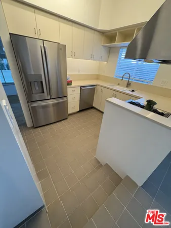 a kitchen with stainless steel appliances a refrigerator sink and stove