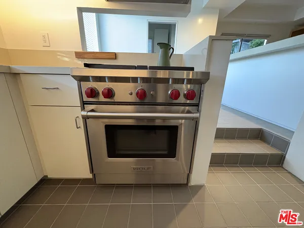 a stove top oven sitting inside of a kitchen