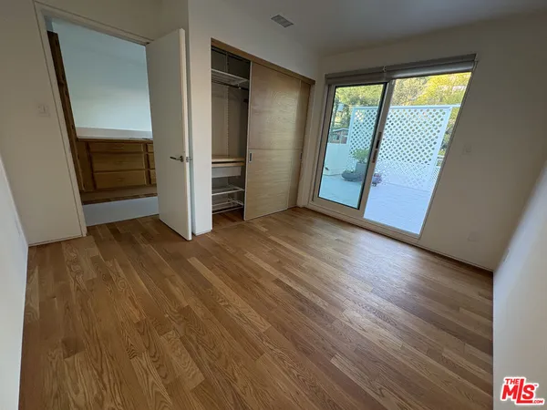 an empty room with wooden floor and entrance