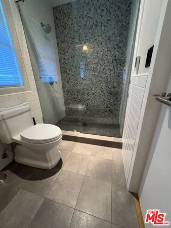 a bathroom with a toilet and a shower