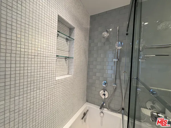 a bathroom with a tub a toilet and a shower