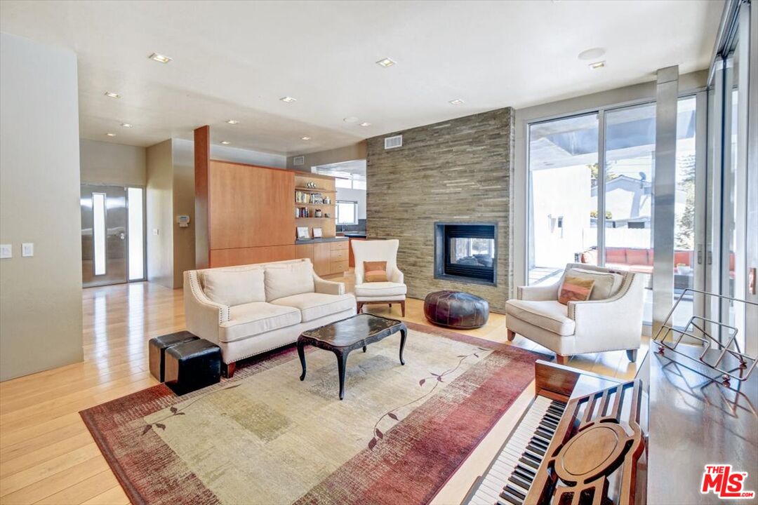 18084 Rancho Street Encino, CA 91316 - Photo 17 of 45 a living room with furniture a fireplace and a table
