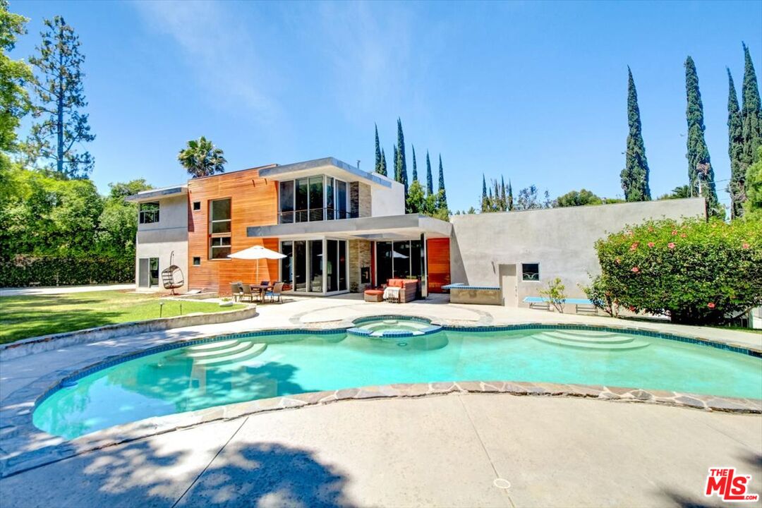 18084 Rancho Street Encino, CA 91316 - Photo 5 of 45 a front view of a house with a yard table and chairs