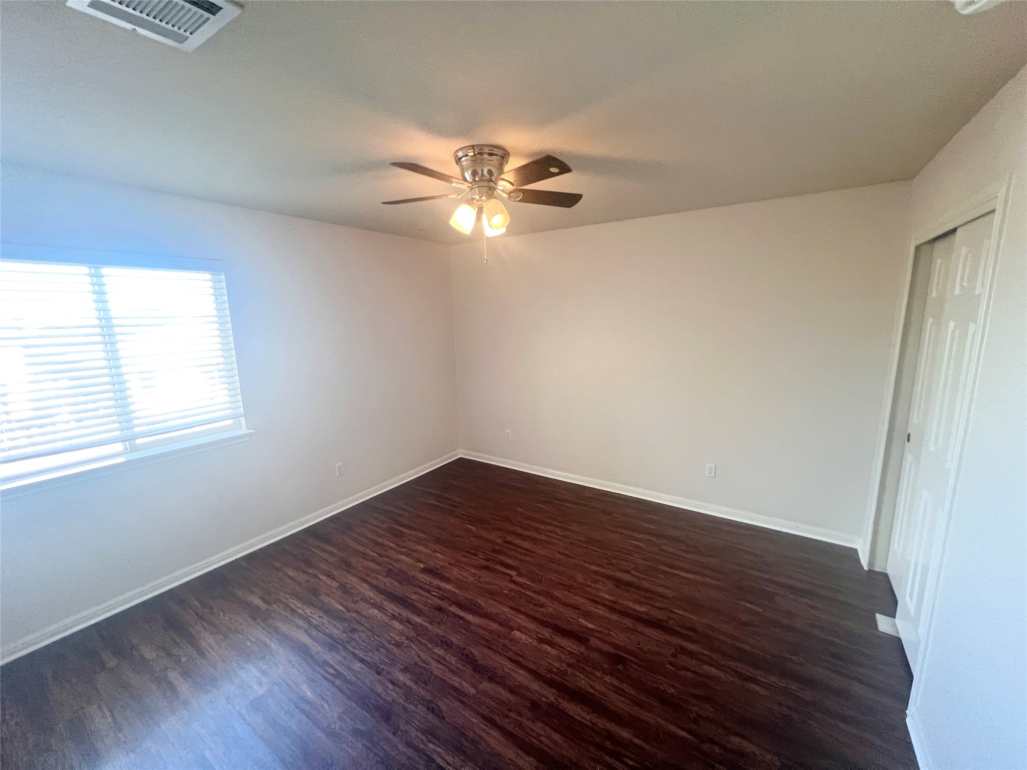 476 Nottingham Loop Kyle, TX 78640 - Photo 16 of 29 an empty room with wooden floor fan and windows