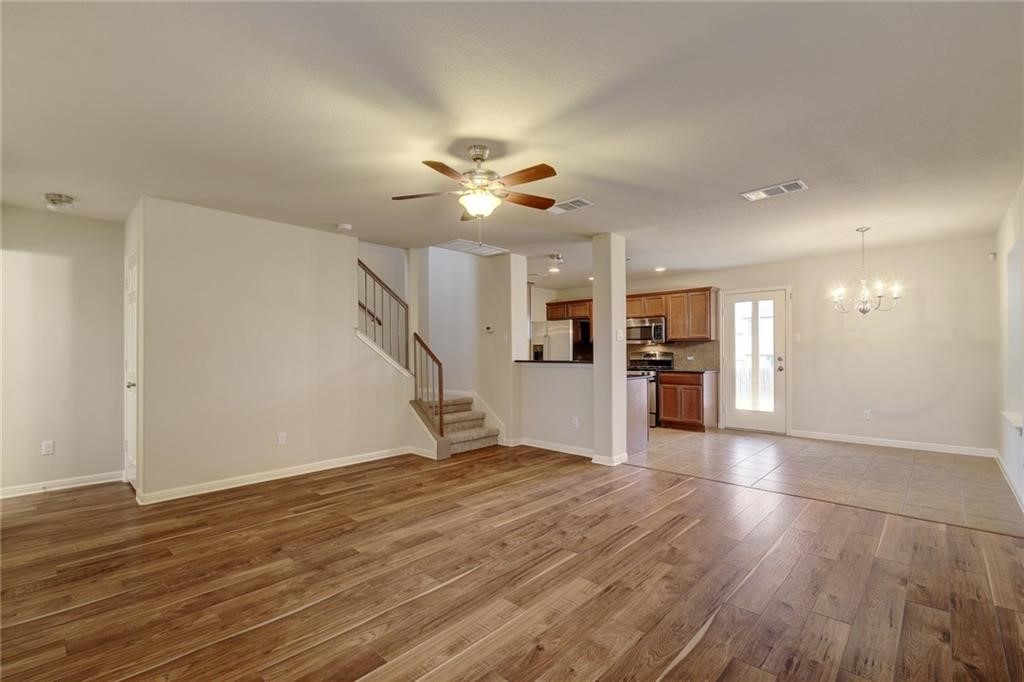 476 Nottingham Loop Kyle, TX 78640 - Photo 4 of 29 a view of an empty room with wooden floor and a ceiling fan