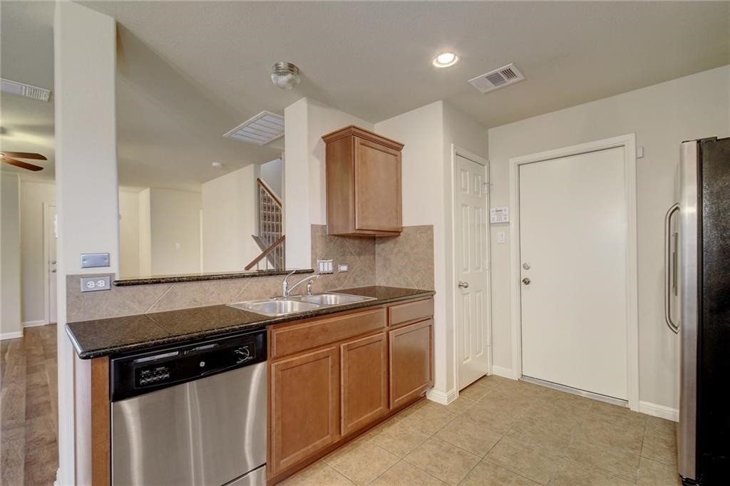 476 Nottingham Loop Kyle, TX 78640 - Photo 7 of 29 a kitchen with stainless steel appliances granite countertop a sink stove and refrigerator