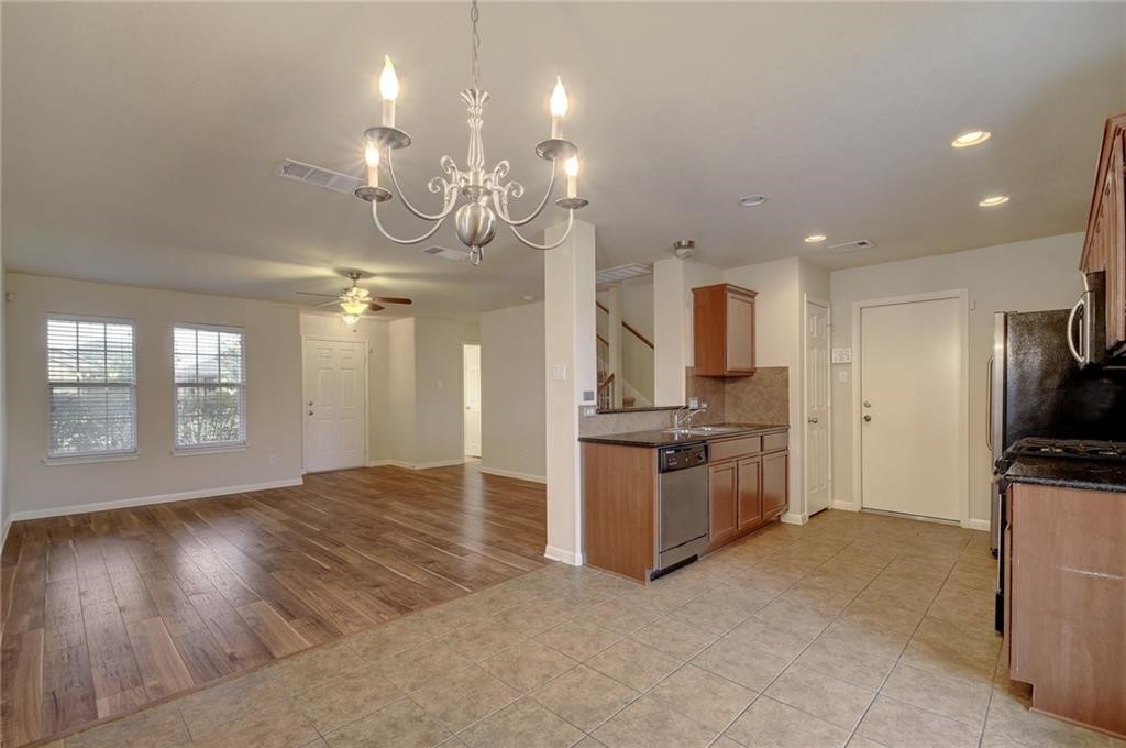 476 Nottingham Loop Kyle, TX 78640 - Photo 10 of 29 a large kitchen with granite countertop a large counter top stainless steel appliances and cabinets