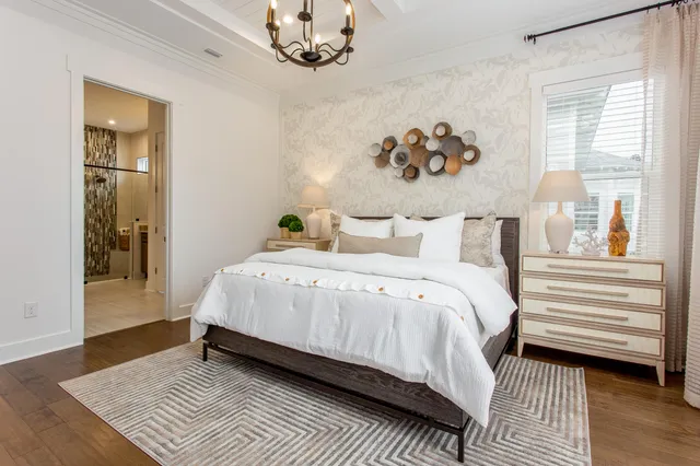 a bedroom with a large bed and a chandelier