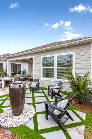 a view of a patio with table and chairs potted plants and floor to ceiling window