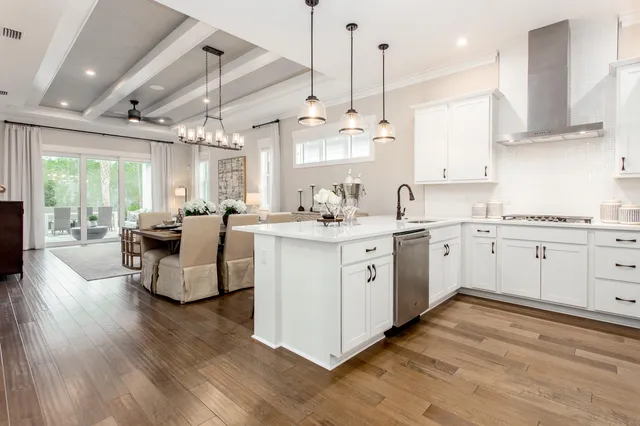 a kitchen with kitchen island granite countertop a sink cabinets and wooden floor