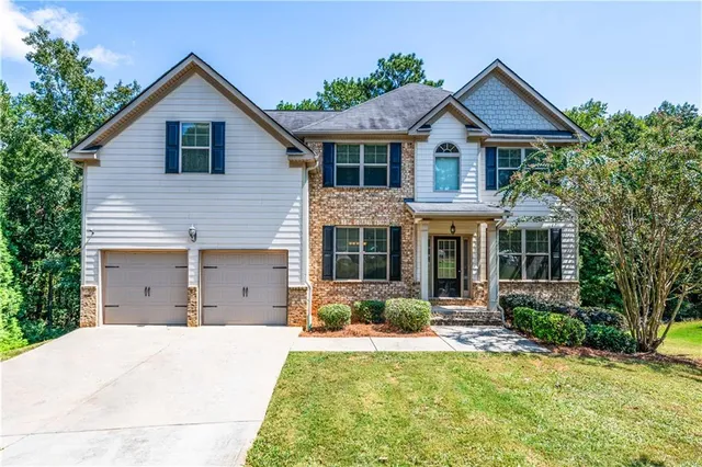 a front view of a house with a yard and garage