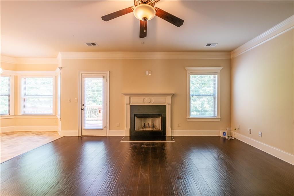 1412 Turnbridge Walk Hampton, GA 30228 - Photo 15 of 40 an empty room with wooden floor fireplace and windows
