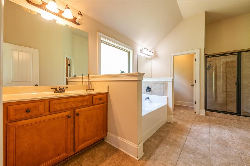 1412 Turnbridge Walk Hampton, GA 30228 - Photo 25 of 40 a bathroom with a sink a mirror and a bathtub