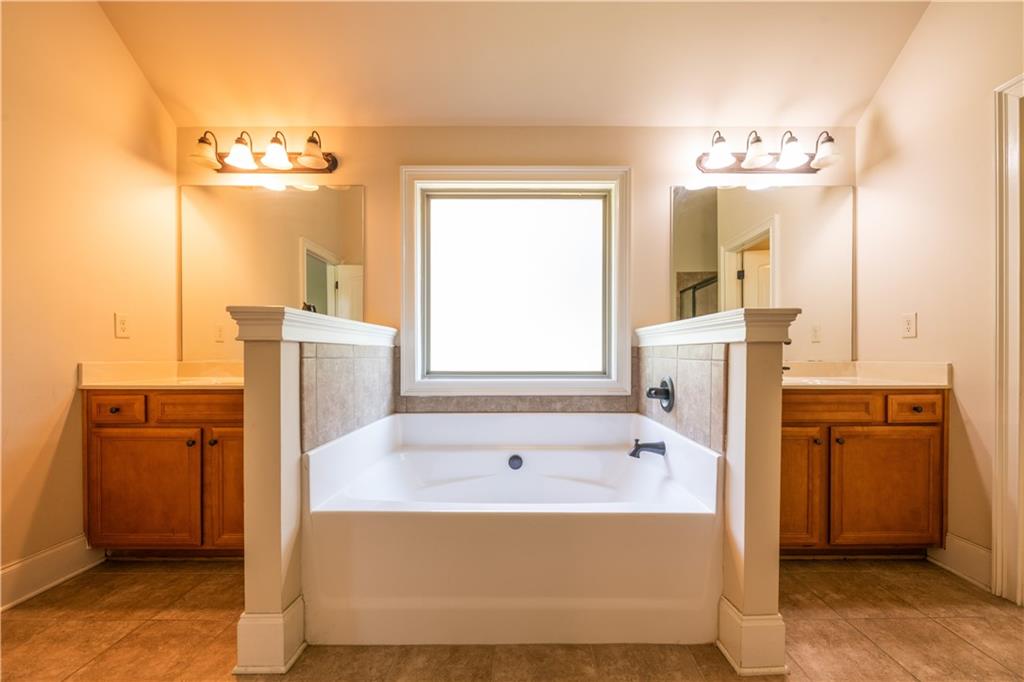 1412 Turnbridge Walk Hampton, GA 30228 - Photo 26 of 40 a bathroom with a tub sink and mirror