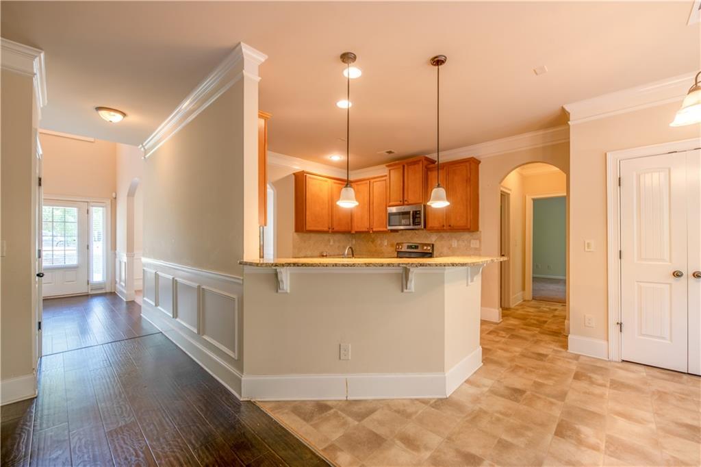 1412 Turnbridge Walk Hampton, GA 30228 - Photo 10 of 40 a view of a kitchen with kitchen island with stainless steel appliances granite countertop cabinets and a wooden floor