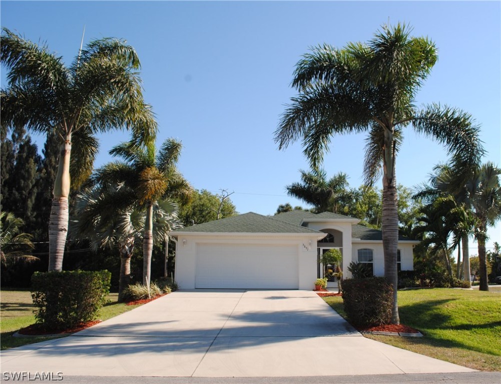 5891 Tarpon Road Bokeelia, FL 33922 - Photo 1 of 25 front view of a house with a yard and palm trees