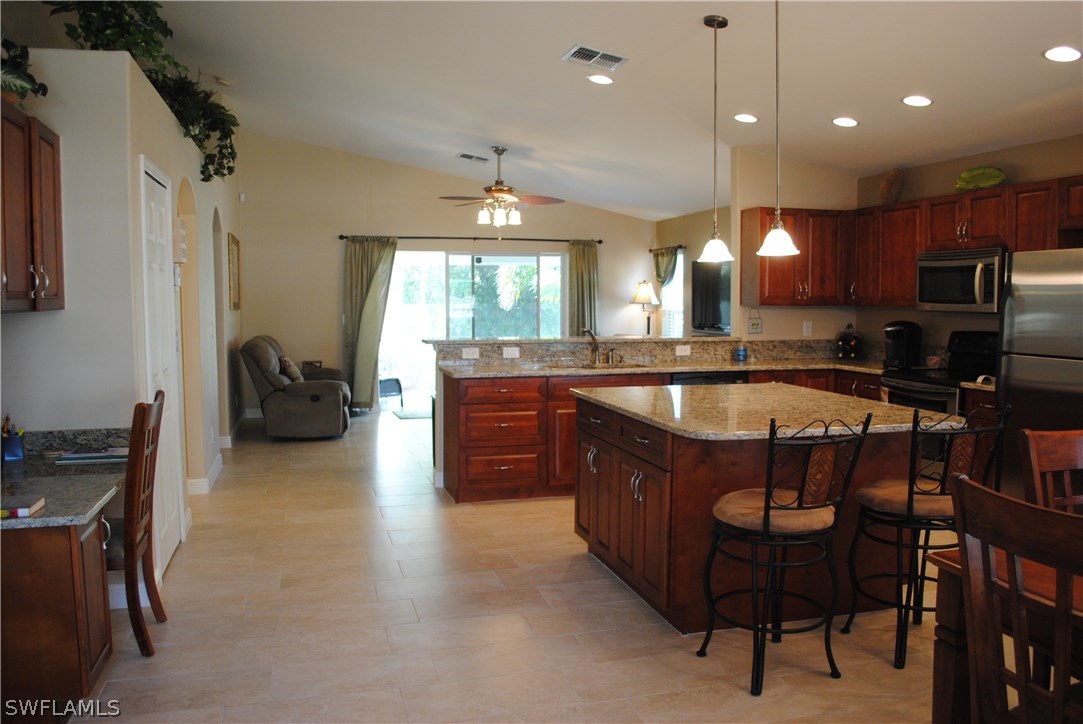 5891 Tarpon Road Bokeelia, FL 33922 - Photo 6 of 25 a kitchen with a table chairs sink and cabinets