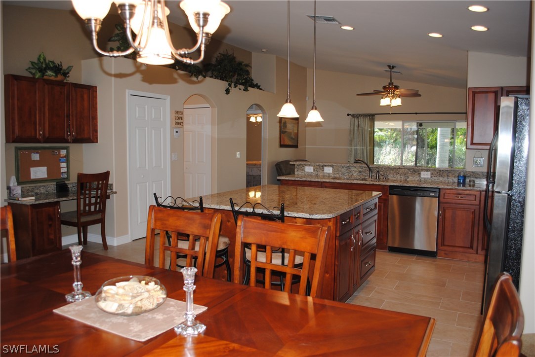 5891 Tarpon Road Bokeelia, FL 33922 - Photo 8 of 25 a kitchen with stainless steel appliances granite countertop a sink a stove and a refrigerator