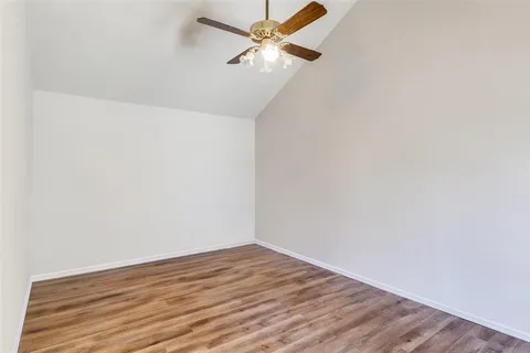 a view of a room with wooden floor and a ceiling fan