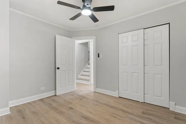 an empty room with wooden floor closet and windows