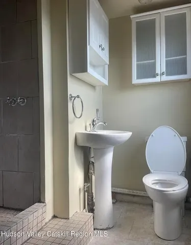 a bathroom with a toilet sink and mirror