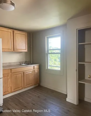 a kitchen with a sink cabinets and wooden floor