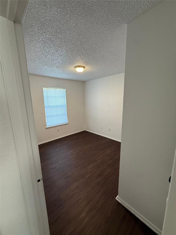 1715 Short Street, Unit D Cleburne, TX 76033 - Photo 5 of 12 Interior room featuring wood-finish flooring, white walls, and a single window with blinds