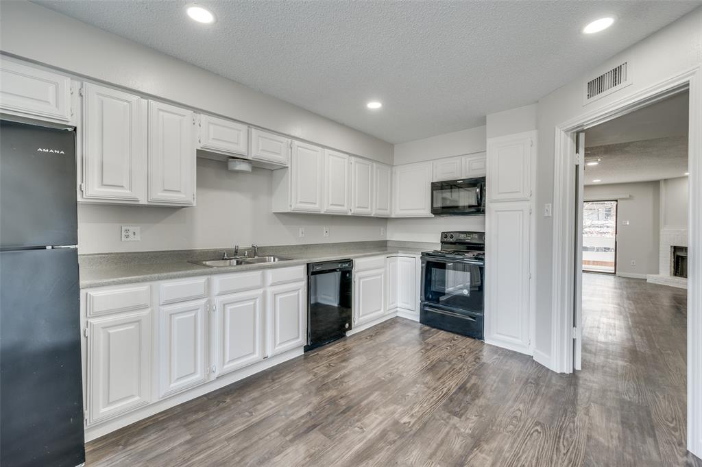 5840 Spring Valley Road, Unit 208 Dallas, TX 75254 - Photo 1 of 1 Kitchen featuring black appliances, a textured ceiling, white cabinetry, and sink